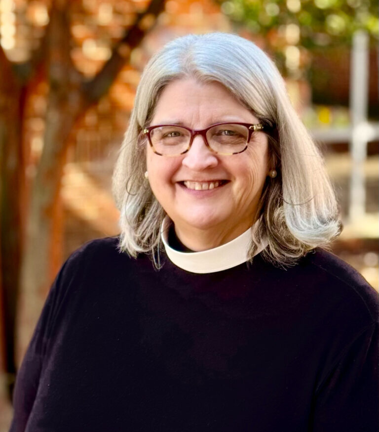 Rev. Gerri Endicot stands in the courtyard at Holy Apostles